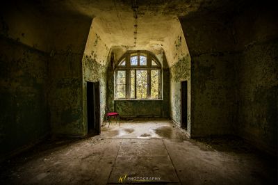 Ein Zimmer mit einem roten Stuhl darin